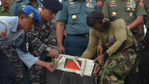 Indonesian military personnel remove Flight Data Recorder of the ill-fated AirAsia flight. (AP)