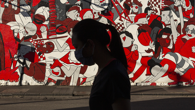  A woman wearing a mask walks past a wall mural in Prahran on September 06, 2020 in Melbourne, Australia. 