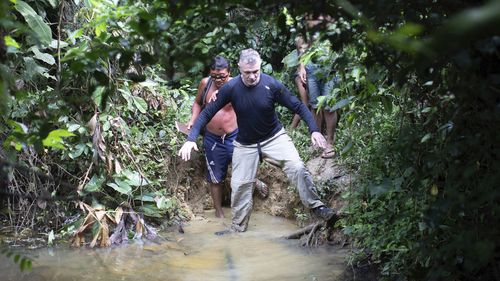 British journalist Dom Phillips, right, and a Yanomami Indigenous man walk in Maloca Papiu village, Roraima state, Brazil, Nov. 2019. Phillips and Indigenous affairs expert Bruno Araujo Pereira have been reported missing in a remote part of Brazil's Amazon region, a local Indigenous association said Monday, June 6, 2022. (AP Photo/Joao Laet)