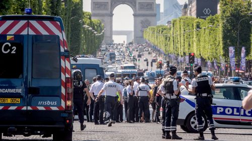 The Arc de Triomphe can be seen in the background of a police incident on the Champs Elysees in Paris. (AAP)