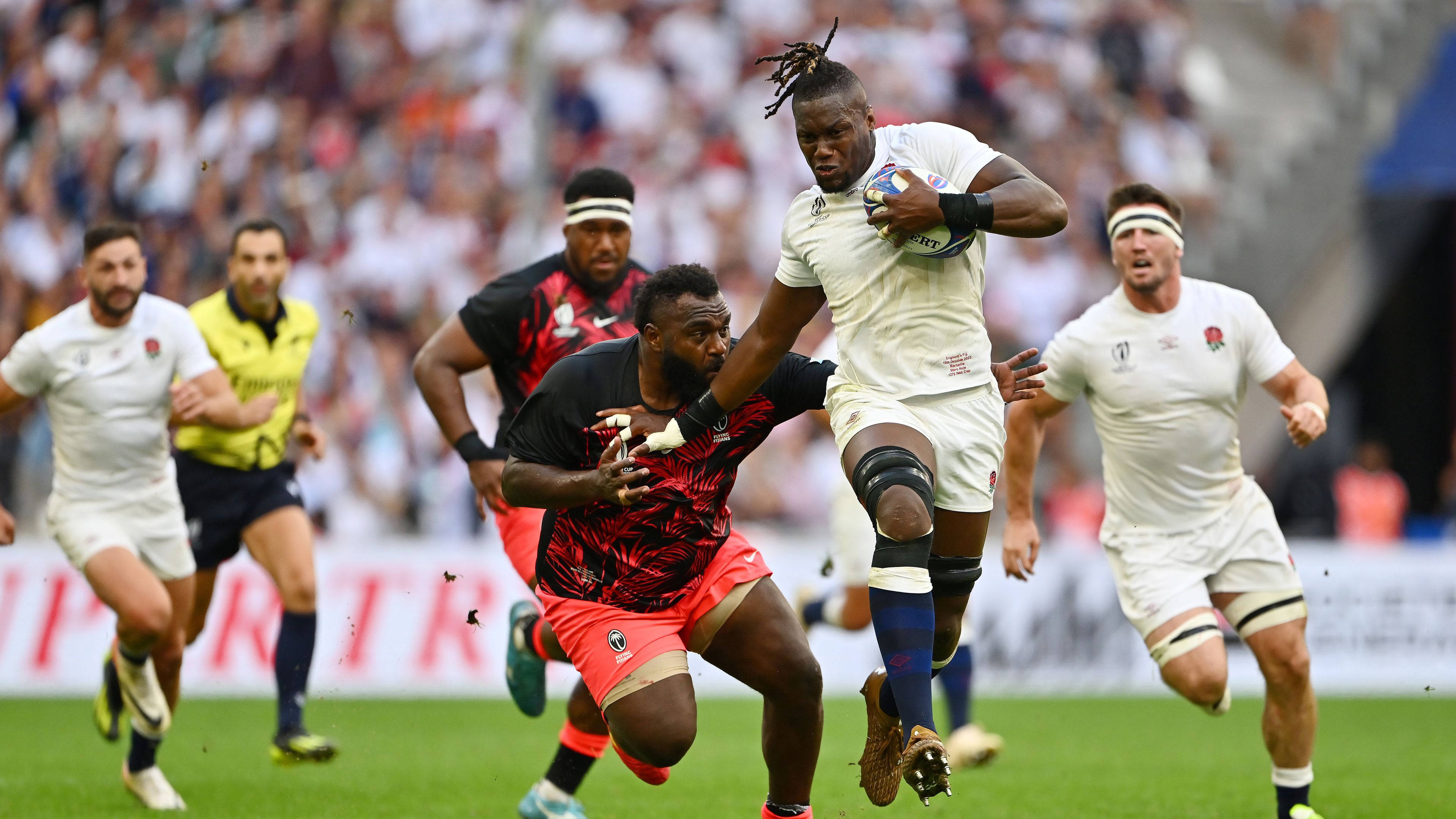 Maro Itoje of England breaks through the tackle of Luke Tagi of Fiji.