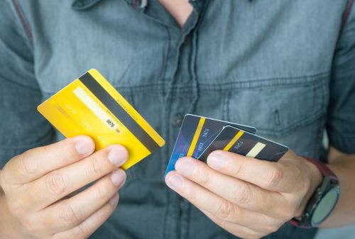 Man holding several credit cards and he is choosing a credit card to pay and spend Payment for goods via credit card. Finance and banking concept.
