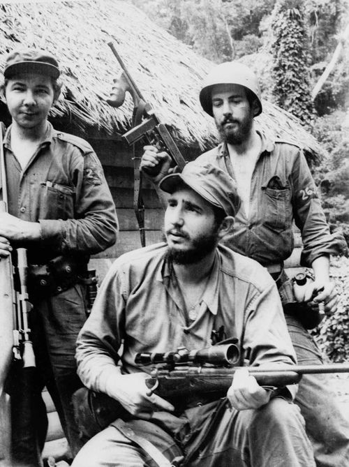 In a photo from 1957, a young Fidel Castro, the young anti-Batista guerrilla leader, center, is seen with his brother Raul Castro, left, and Camilo Cienfuegos, while operating in the mountains of eastern Cuba. (AAP)