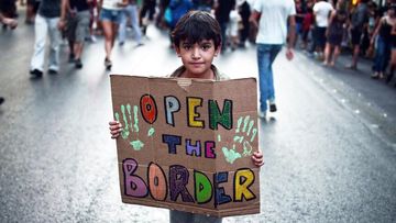 A file photo taken on August 29, 2016 shows a child holding a placard reading "Open the border" during a demonstration in support to refugees and migrants in front of Athens municipality building, in Athens. (AFP)