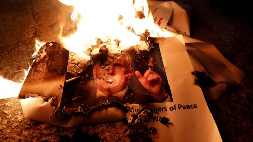 Palestinians burn the picture of the US Vice President Mike Pence during a protest against Mr Trump's decision to announce Jerusalem as the capital of Israel and the visit of Pence in the West Bank city of Bethlehem. (EPA)