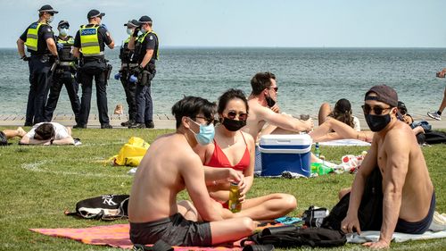  Victoria Police patrol St Kilda beach in Melbourne, as groups of young people wear masks in the sunshine.