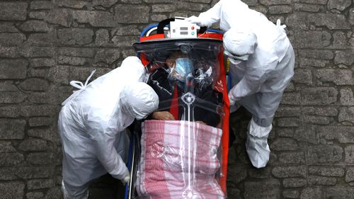 Medical staff in protective gear move a patient infected with the coronavirus from an ambulance to a hospital in Seoul, South Korea.