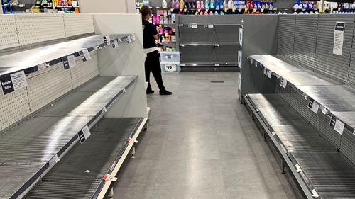 Empty shelves of toilet paper are seen at a supermarket in Sydney's CBD.
