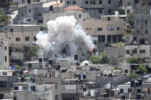 Smoke rises from an explosion during an Israeli military raid in the Nur Shams refugee camp, 