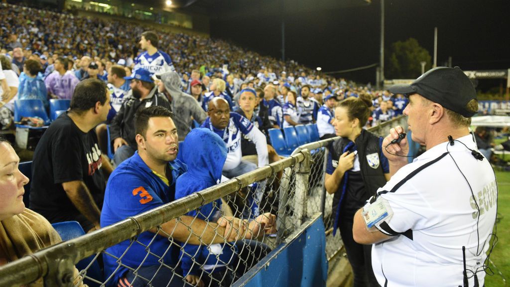 Security guards look towards an area where a bottle was thrown from at Belmore Oval. (AAP)