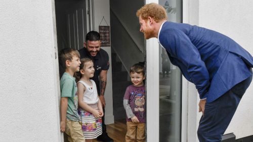 Prince Harry visits Simon Flores and his family 5-year old Lily Anne Flores and her brothers Kobbi and Damaso during his visit Walking With The Wounded (WWTW) hub for ex-service personnel this week. (AAP)
