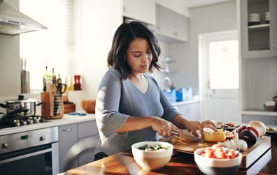 Woman cooking at home in front of stove.