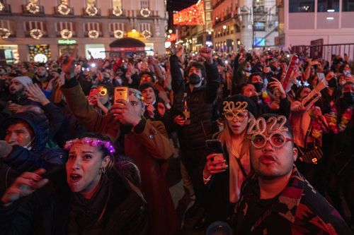 La gente festeggia durante i festeggiamenti di Capodanno alla Puerta del Sol di Madrid, nel centro di Madrid, in Spagna, sabato 1 gennaio 2022.