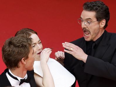 Emma Stone tries to avoid a bee next to Austin Butler and Pedro Pascal at the premiere of Eddington during the 78th annual Cannes Film Festival, in Cannes, France, 16 May 2025 