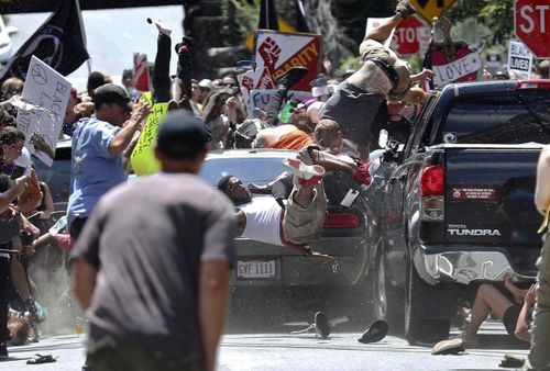 In this Aug. 12, 2017, file photo, people fly into the air as a vehicle is driven into a group of protesters demonstrating against a white nationalist rally in Charlottesville, Va. Federal hate crime charges have been filed against James Alex Fields Jr., accused of driving the car. (Ryan M. Kelly/The Daily Progress via AP, File)