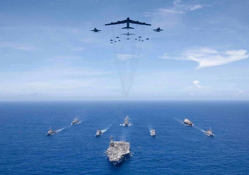 The aircraft carrier USS Ronald Reagan leads a formation of Carrier Strike Group 5 ships as US Air Force B-52 Stratofortress aircraft and US Navy F/A-18 Hornets fly over head