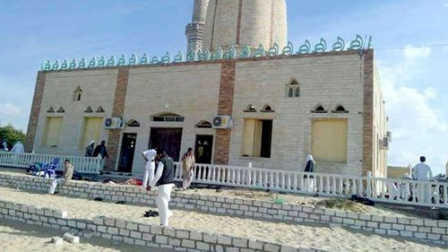 People walk outside a mosque that was attacked in the northern city of Arish, Sinai Peninsula, Egypt. (AAP)