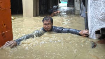 A man negotiates neck-deep floodwaters in his village caused by Typhoon Doksuri in Laoag city, Ilocos Norte province, northern Philippines, Wednesday, July 26, 2023. Typhoon Doksuri blew ashore in a cluster of islands and lashed northern Philippine provinces with ferocious wind and rain Wednesday, leaving at least a few people dead and displacing thousands of others as it blew roofs off rural houses, flooded low-lying villages and toppled trees, officials said. (AP Photo/Bernie Sipin Dela Cruz)