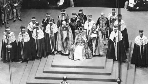Surrounded by peers and churchmen, the newly-crowned Queen Elizabeth II sits on the throne in Westminister Abbey on June 2, 1953.