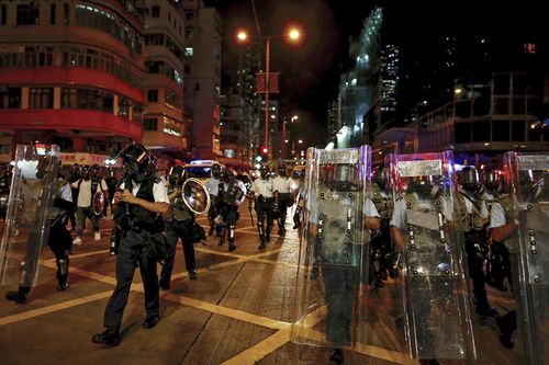 Policemen with riot gear march on a street as they confront protesters in Hong Kong (AP Photo/Vincent Yu)