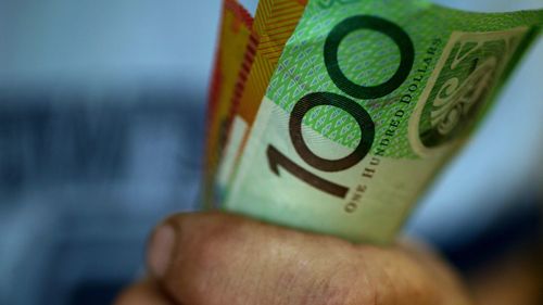 Someone clutching a handful of $50 and $100 notes.