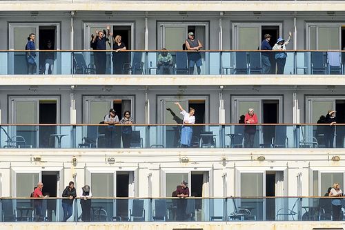 Passenger aboard the Grand Princess celebrate as they arrive in Oakland, California. The cruise ship, which had maintained a holding pattern off the coast for days, is carrying multiple people who tested positive for COVID-19.