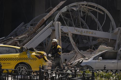 A sign for the five-star Hotel Saratoga hangs amid the rubble after it was heavily damaged by a deadly explosion in Old Havana, Cuba, Friday, May 6, 2022 