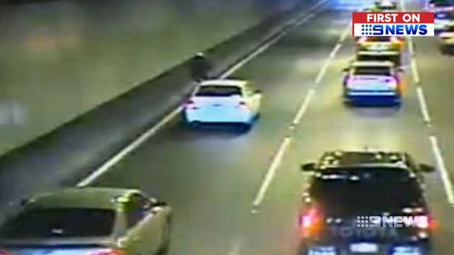 A cyclist squeezed up against a tunnel wall.