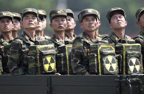  In this July 27, 2013, file photo, North Korean soldiers turn and look towards their leader Kim Jong Un from a military parade vehicle as they carry packs marked with the nuclear symbol during a ceremony marking the 60th anniversary of the Korean War armistice in Pyongyang, North Korea. North Korea has conducted five nuclear tests, the first in 2006. All were conducted in the depths of Mount Mantap, a nondescript granite peak in the remote and heavily forested Hamgyong mountain range about 80 kilometers (50 miles) as the crow flies from Chongjin, the nearest big city. Since North Korea is the only country in the world that still conducts nuclear weapons tests, its Punggye-ri site on _ or mostly under - Mount Mantap is also the worldâs only active nuclear testing site. (AP Photo/Wong Maye-E, File)
