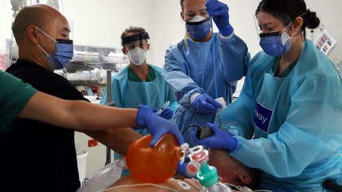 Doctors in a Sydney hospital work on a patient with COVID-19.