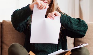 Woman tearing up piece of paper