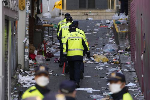 Police officers work at the scene of the fatal crowd surge, in Seoul, South Korea.