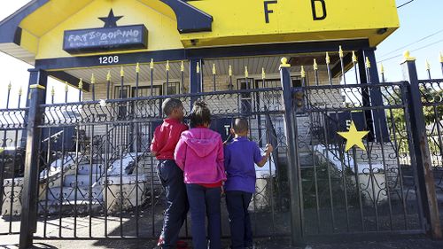 Fans peer through the fence of the former home of famed musician Fats Domino. (AAP)