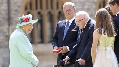 Britain's Queen Elizabeth talks with Captain Sir Thomas Moore and his family after awarding his knighthood during a ceremony at Windsor Castle in Windsor, England, Friday, July 17, 2020