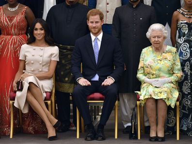 The Queen, Harry and Meghan pose for a group photo at the Queen's Young Leaders Awards Ceremony at Buckingham Palace in London. 