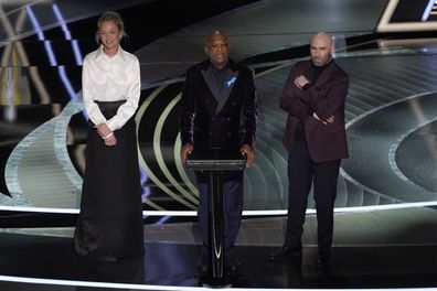 Uma Thurman, from left, Samuel L. Jackson and John Travolta present the award for best performance by an actor in a leading role at the Oscars on Sunday, March 27, 2022, at the Dolby Theatre in Los Angeles. (AP Photo/Chris Pizzello)