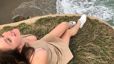 Tourist Nataliia Bodnar poses for a photo at Dunedin's Tunnel Beach.