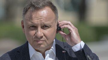 Polish President Andrzej Duda listens through an earpiece to Ukrainian President Volodymyr Zelenskyy during a joint news conference in Kyiv, Ukraine, Tuesday, Aug. 23, 2022.