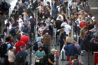 Travellers negotiate crowds at the Departure Terminal at Sydney Airport at the beginning of Easter School Holidays, 2022.