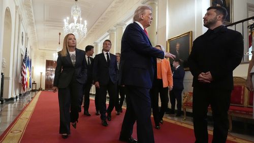 Ukrainian President Volodymyr Zelenskyy, from right, President Donald Trump, France's President Emmanuel Macron and Italy's Prime Minister Giorgia Meloni walk through the Cross Hall of the White House, Monday, Aug. 18, 2025, in Washington.