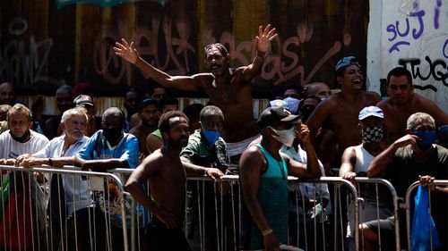A group made up of homeless people, street vendors, and people in situations of social vulnerability line up at a food distribution centre in Rio de Janeiro, Brazil.