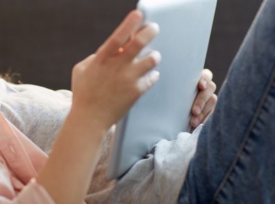 Girl using iPad on lounge