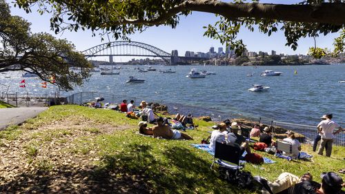 SYDNEY, AUSTRALIA - DECEMBER 31: A small group of people are seen at Mrs Macquaries Point with limited numbers during New Year's Eve celebrations on December 31, 2021 in Sydney, Australia. New Year's Eve celebrations continue to be somewhat different as some COVID-19 restrictions remain in place due to the ongoing coronavirus pandemic. (Photo by Jenny Evans/Getty Images)