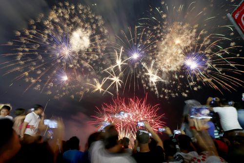 Filipino revelers watch as fireworks light up the sky to welcome the New Year Monday, Jan. 1, 2018 at the seaside Mall of Asia in suburban Pasay city south of Manila, Philippines. Hours before midnight, authorities had already reported dozens have been injured by celebratory firecrackers in the Philippines, which has some of the most raucous New Year celebrations in Asia. (AAP)