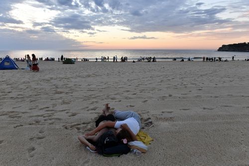 A couple watches the sunrise.