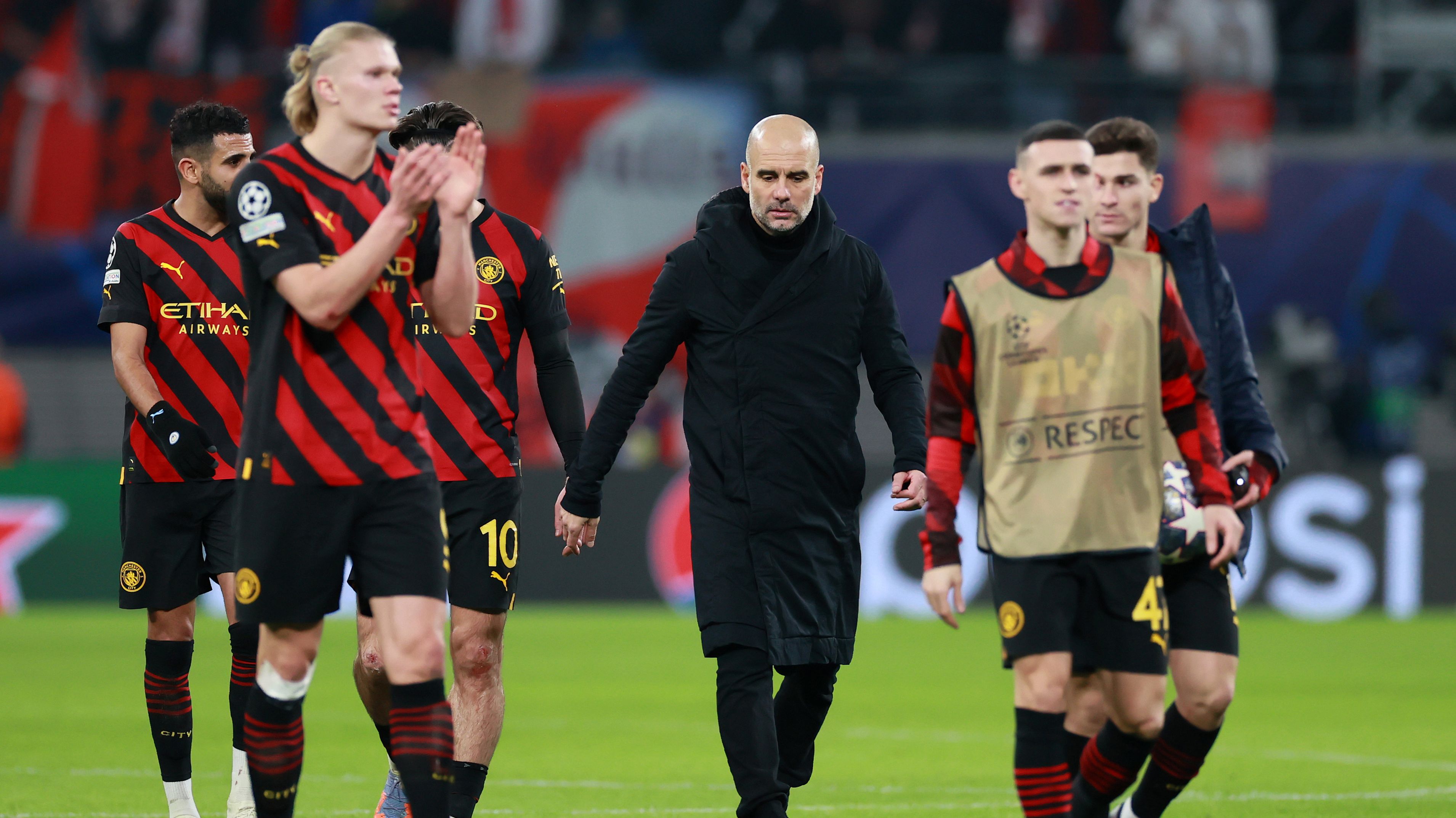 Pep Guardiola walks off the pitch with his players at Red Bull Arena.