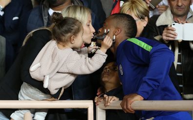 Patrice Evra kisses Sandra while his children Lenny Evra and Maona Evra look on after the UEFA Champions League Quarter Final.