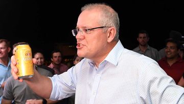 Scott Morrison brandishes his Queensland credentials with a can of XXXX.