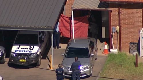 Police hold up a sheet as Vincent Stanford is transferred to Griffith Local Court. (9NEWS Choppercam)