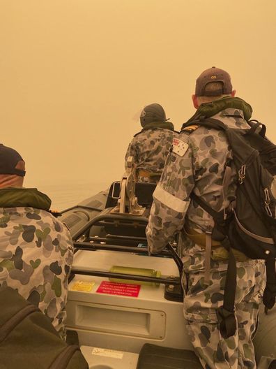 In this photo provided by the Australian Defence Force a tender from HMAS Choules motors through smoke haze off the coast of Mallacoota, Australia, Thursday, Jan. 2, 2020. (ADF via AP)